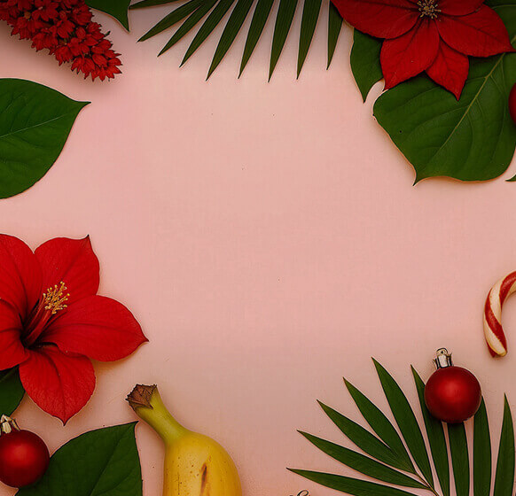 Pink background with green leaves, flowers, Canary Islands fruits, and Christmas decorations.
