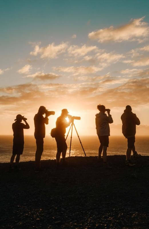 Birdwatcher silhouettes with binoculars in the Canary Islands.