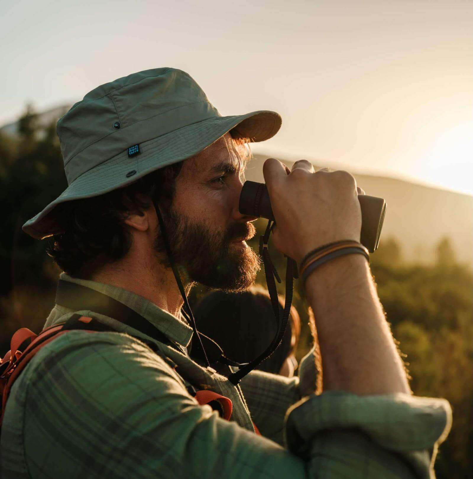 Birdwatcher with binoculars at dawn in natural surroundings of the Canary Islands.