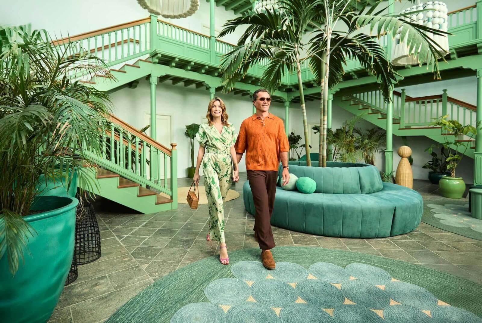 Couple walking through a hallway inspired by traditional Canarian architecture, with light and tropical vegetation.