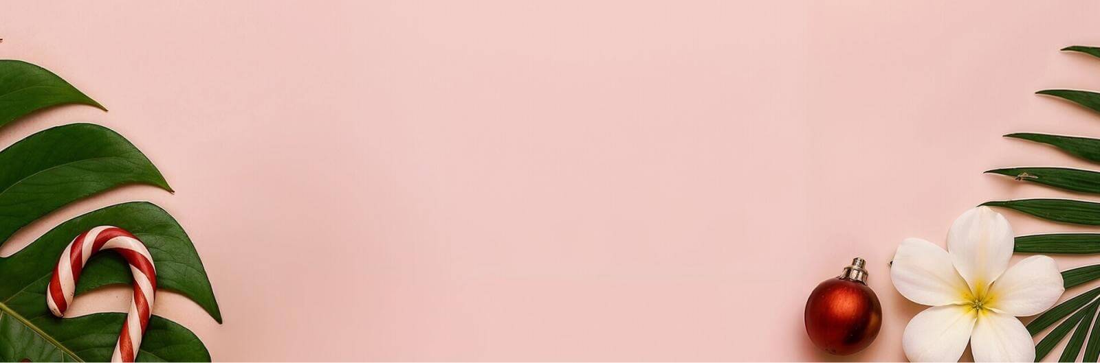 Pink background with green leaf, flower, and Christmas decorations.